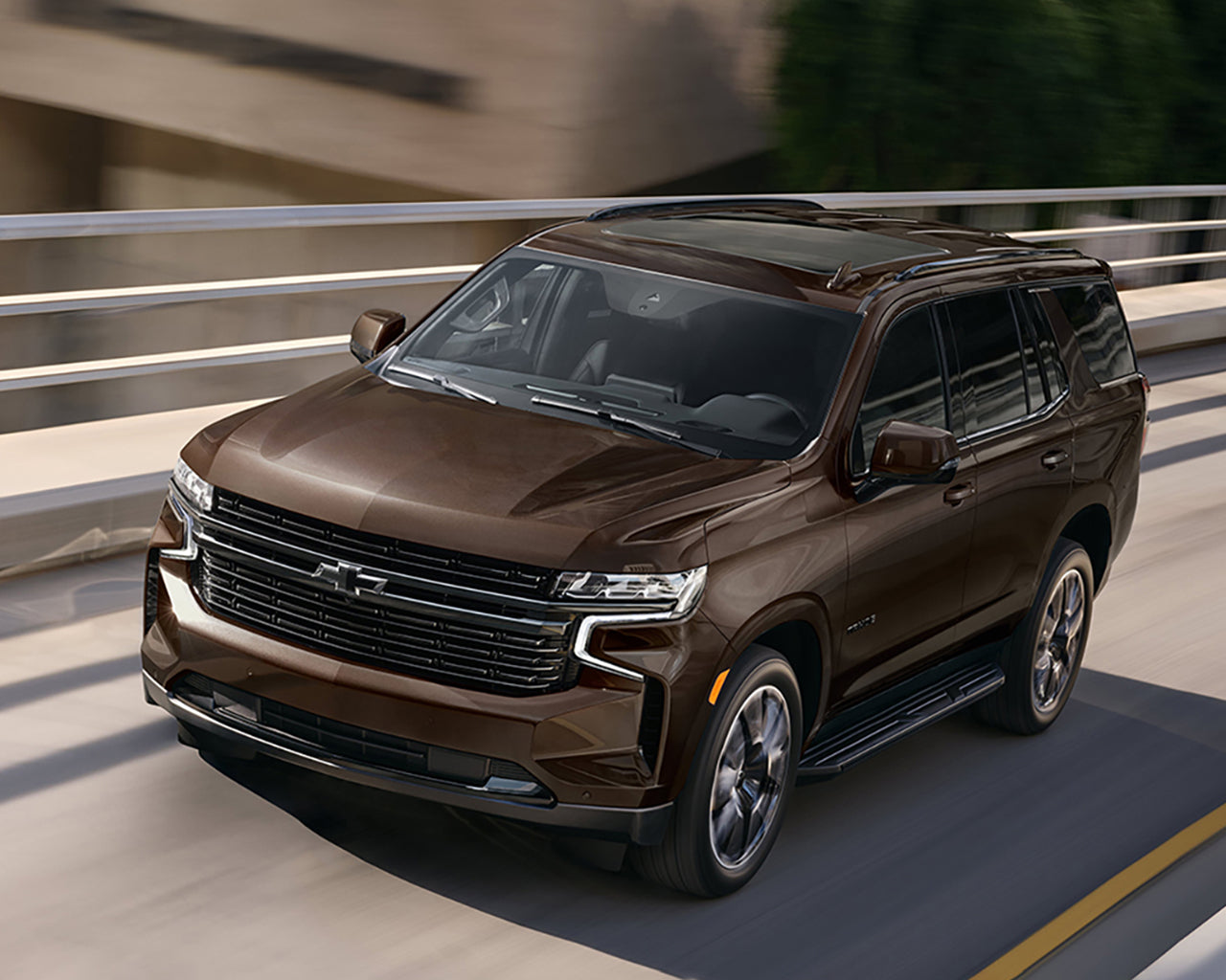 Brown Chevrolet Tahoe driving fast on an overpass